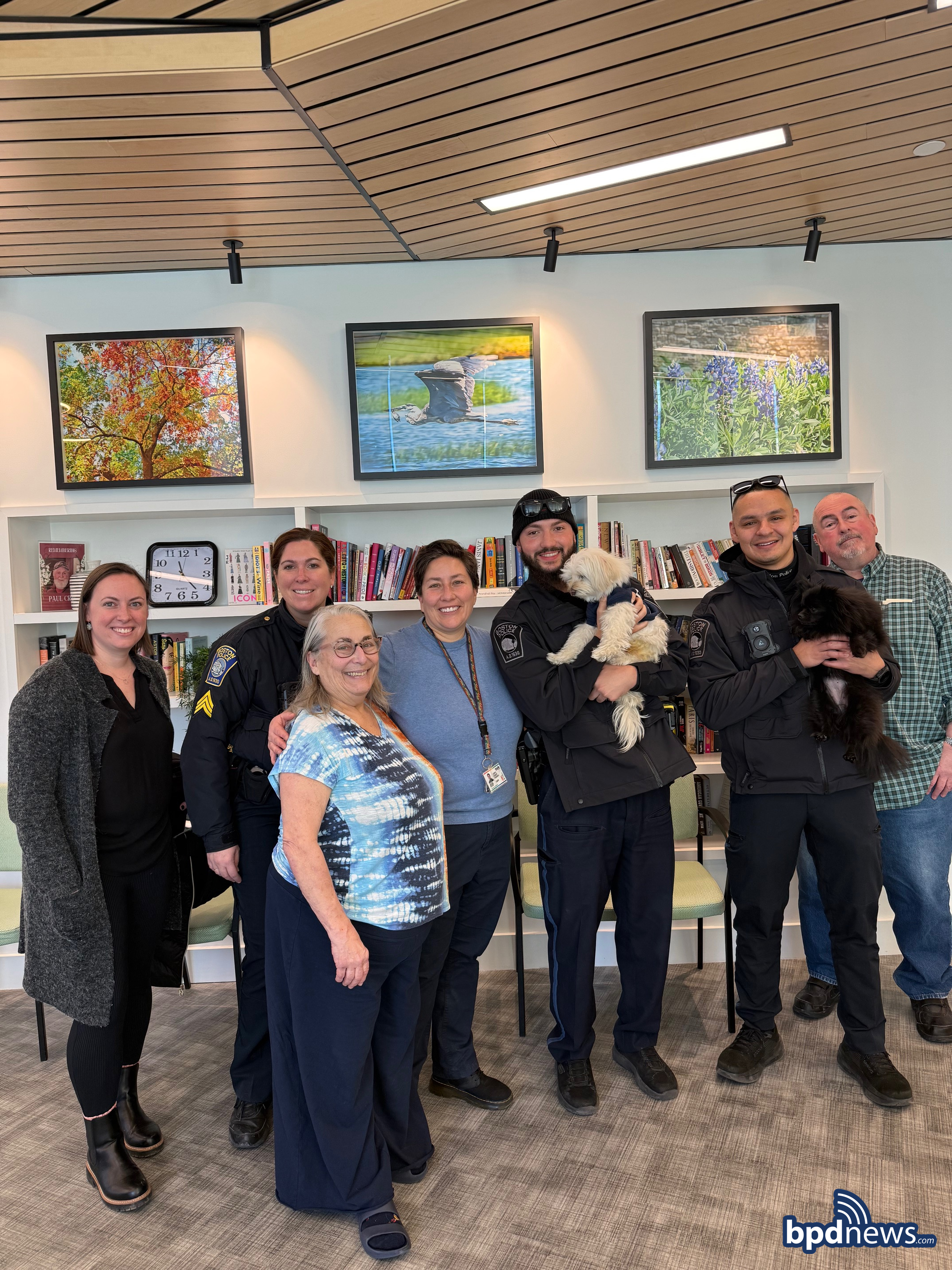 Officers from District E-18 posing for a picture with community members and dogs from the Pryde Senior Living
