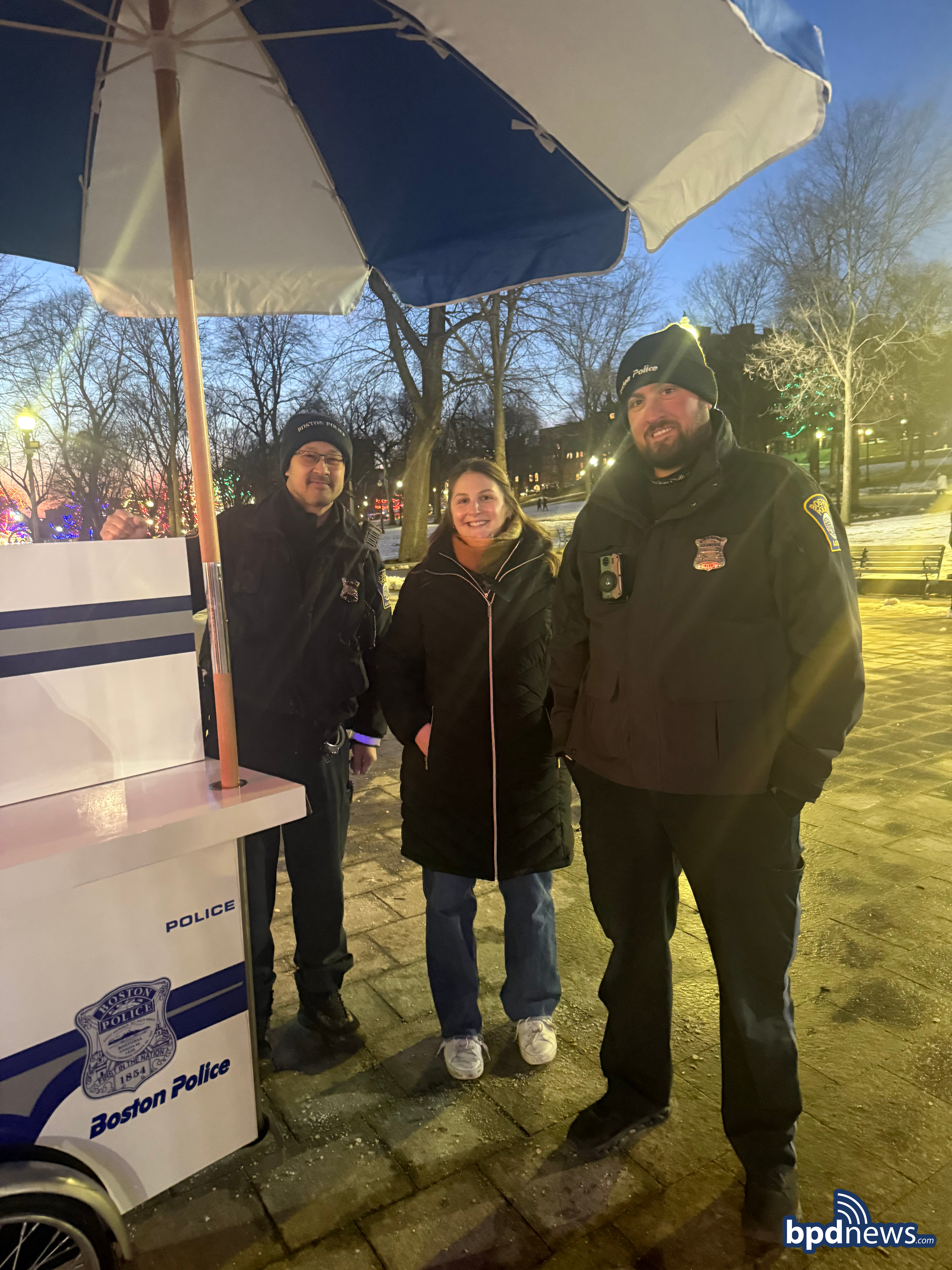 District A-1 officers posing with community member alongside the Boston Police Hot Chocolate Cart