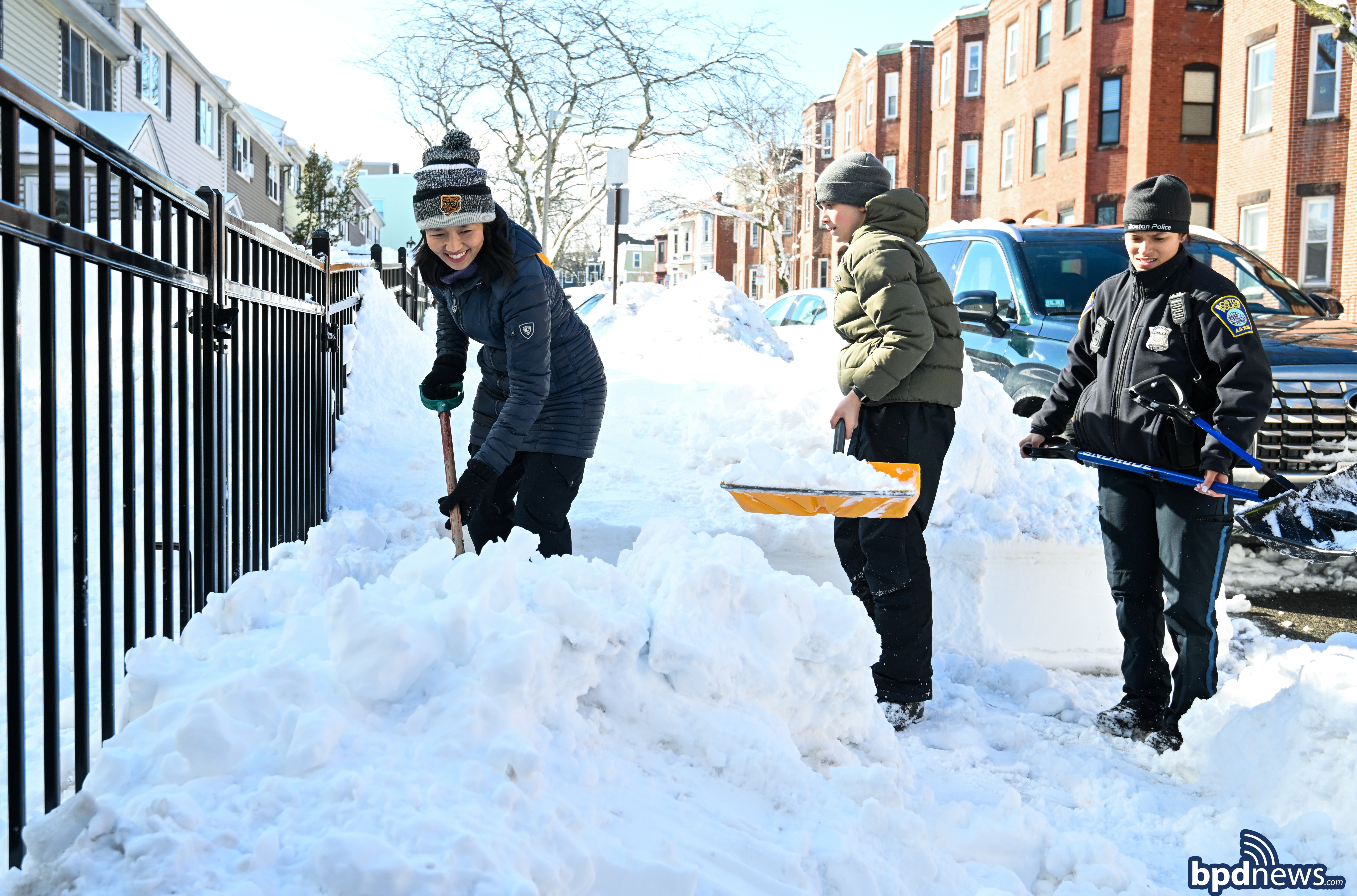 Mayor Michelle Wu, community members, and BPD Officers shoveling snow
