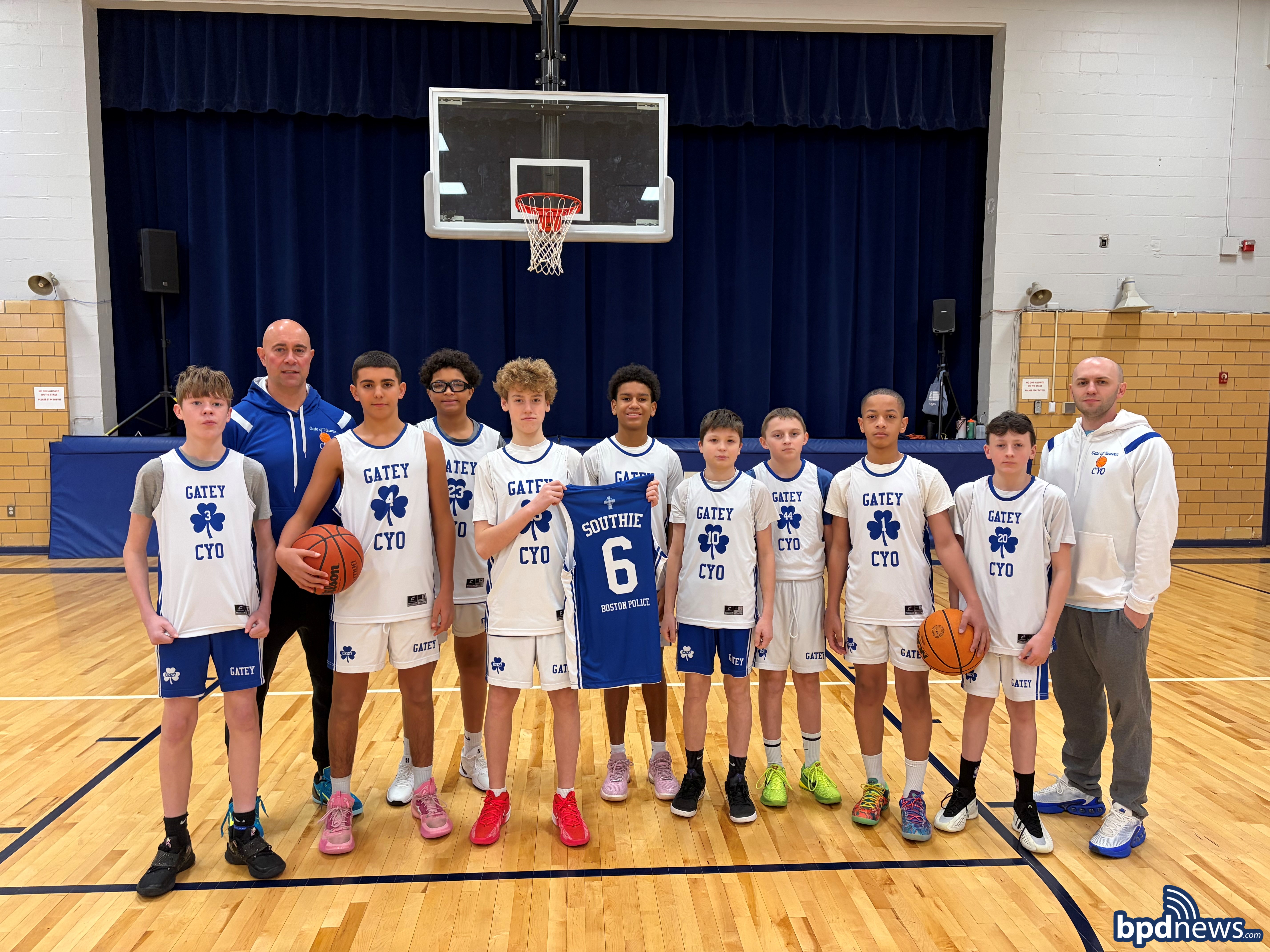 Boston Police Civilian Staff pose for group picture with basketball players from the Gatey CYO Team