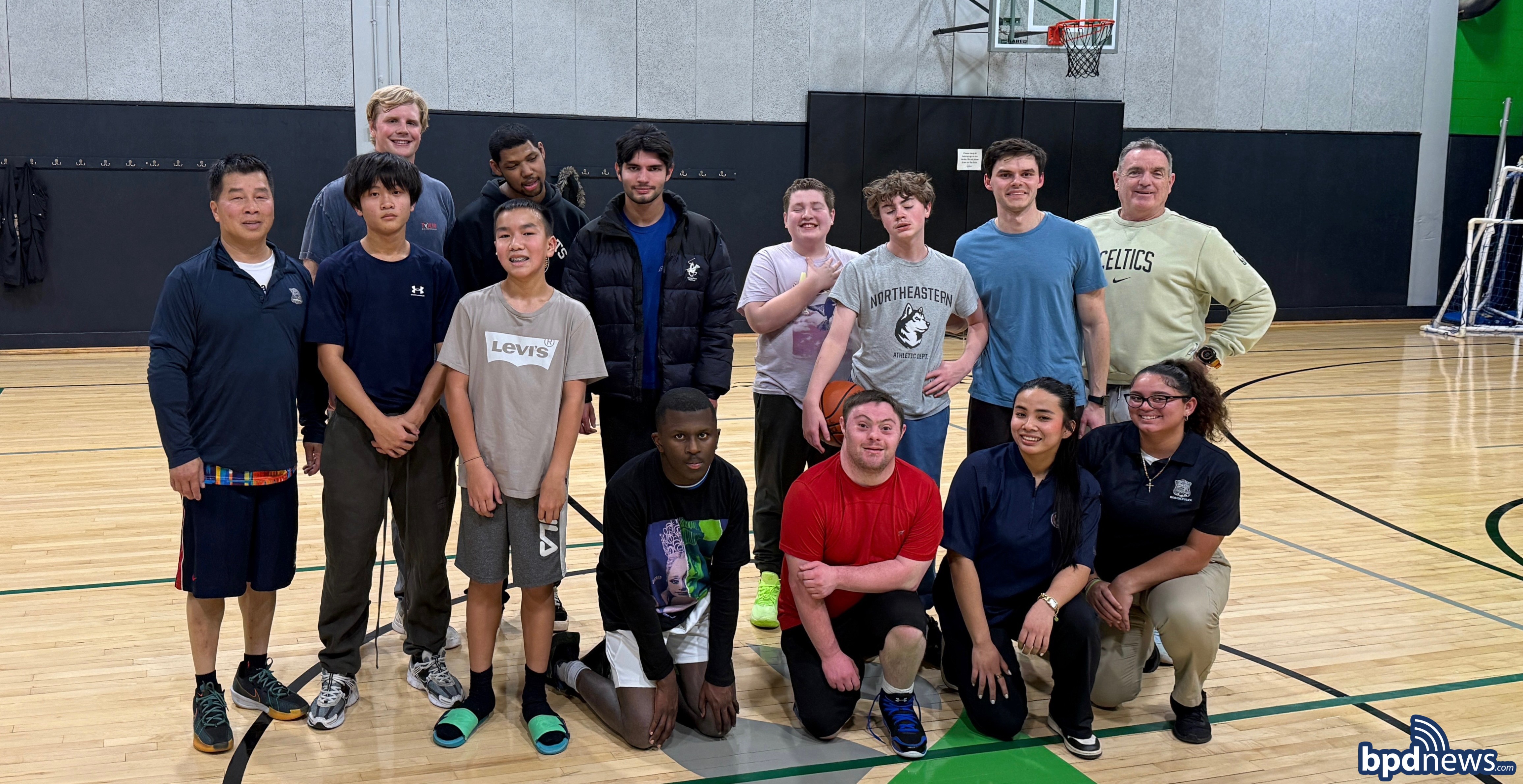Officers and Cadets Pose for a group photo with a community members involved in the Basketball Partnership Program