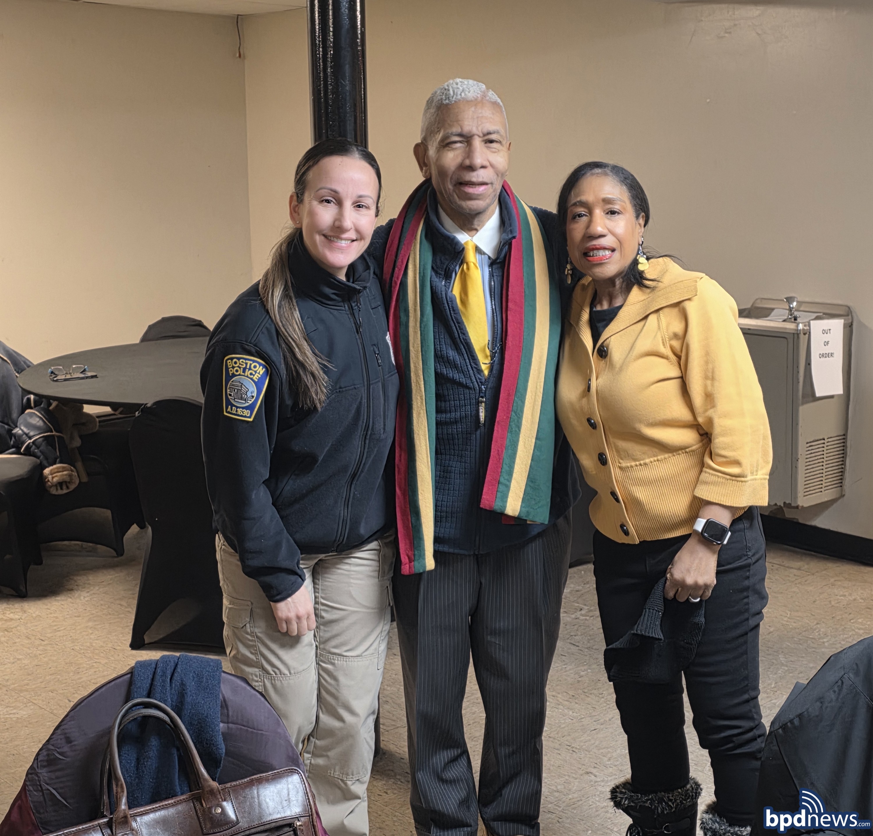 A Boston Police Officer poses with community members for a picture