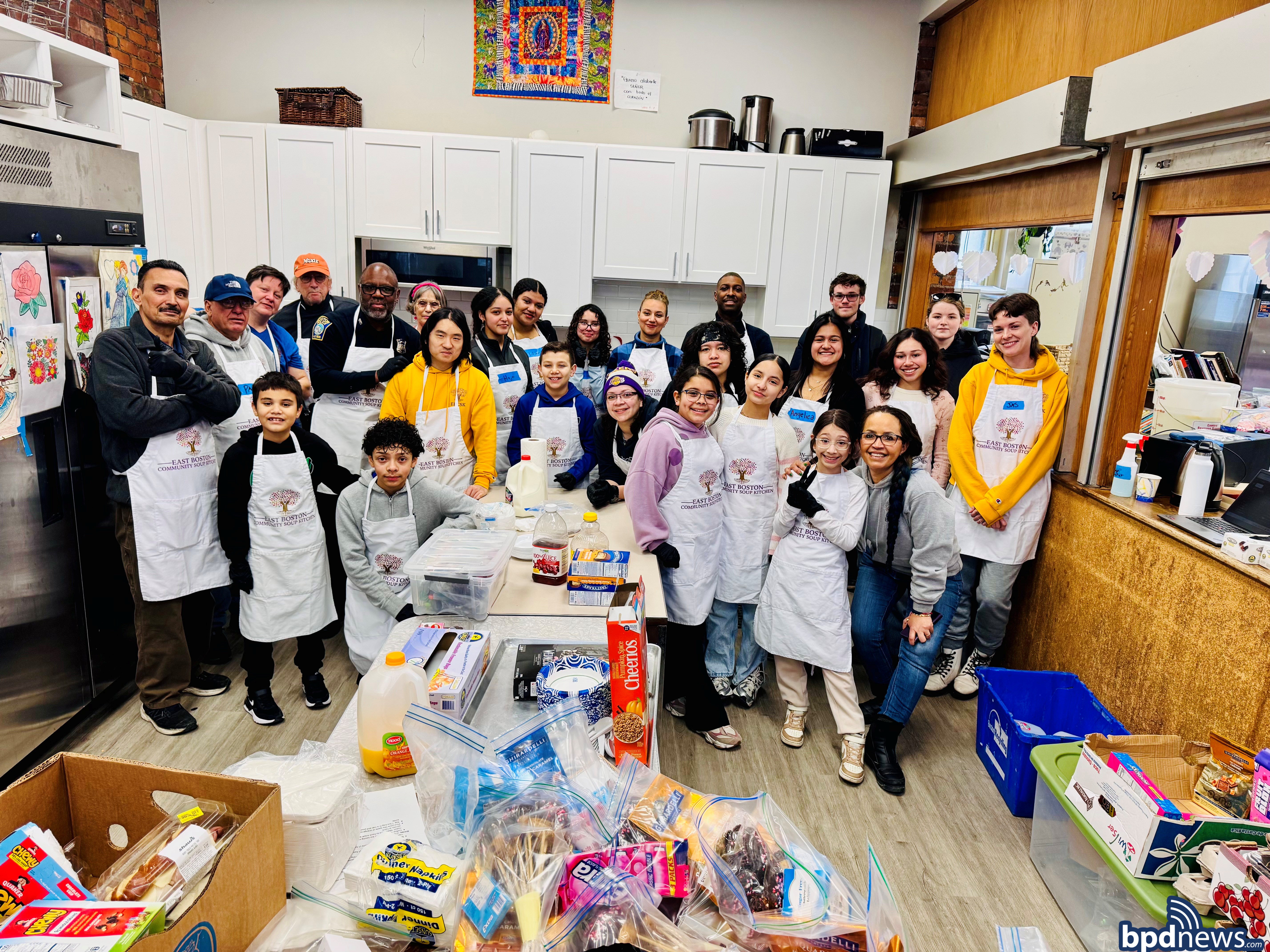 Boston Police Officer Poses for a group picture with Community Members at the East Boston Soup Kitchen