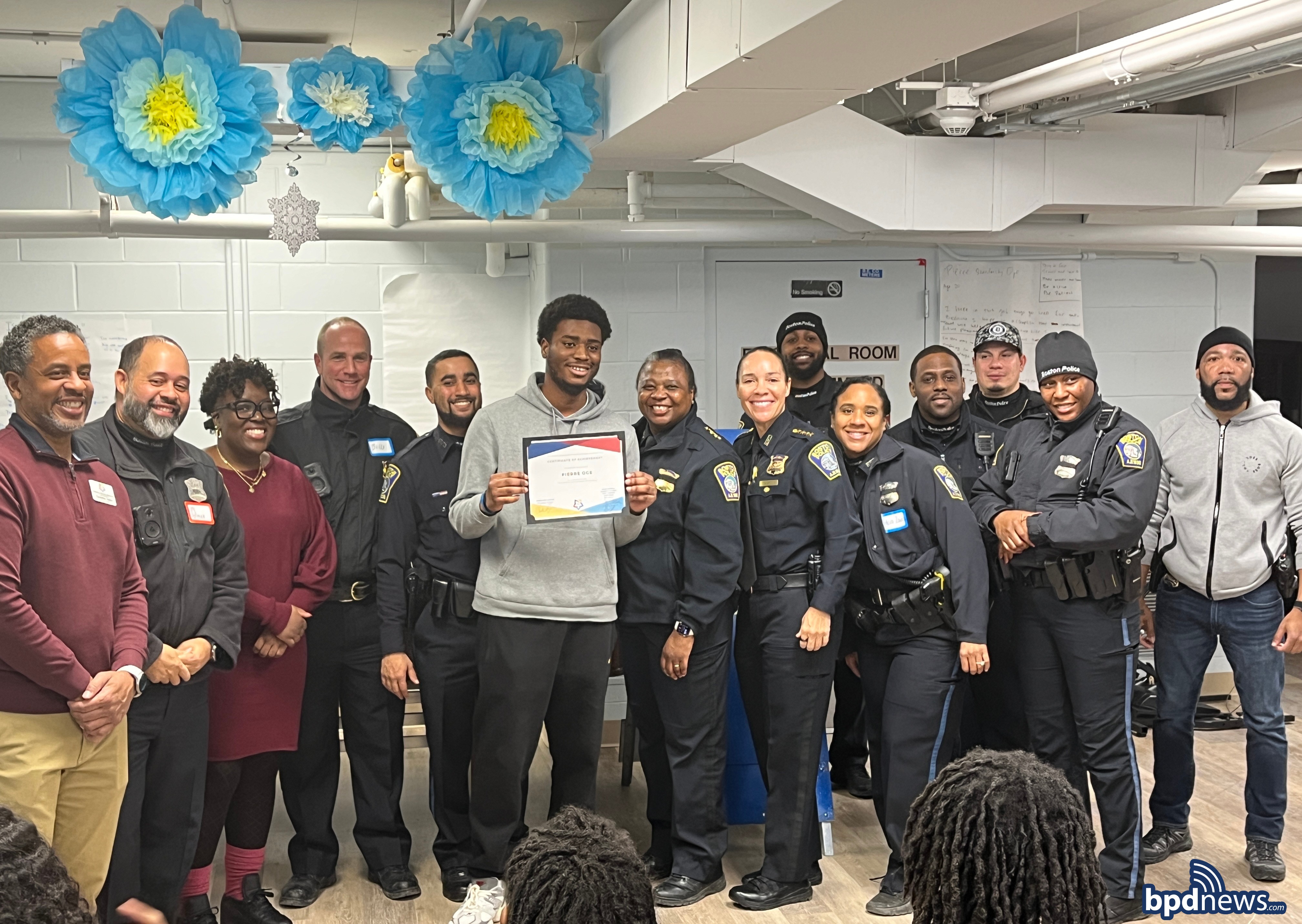 A community member who won an award poses for a group picture with BPD officers